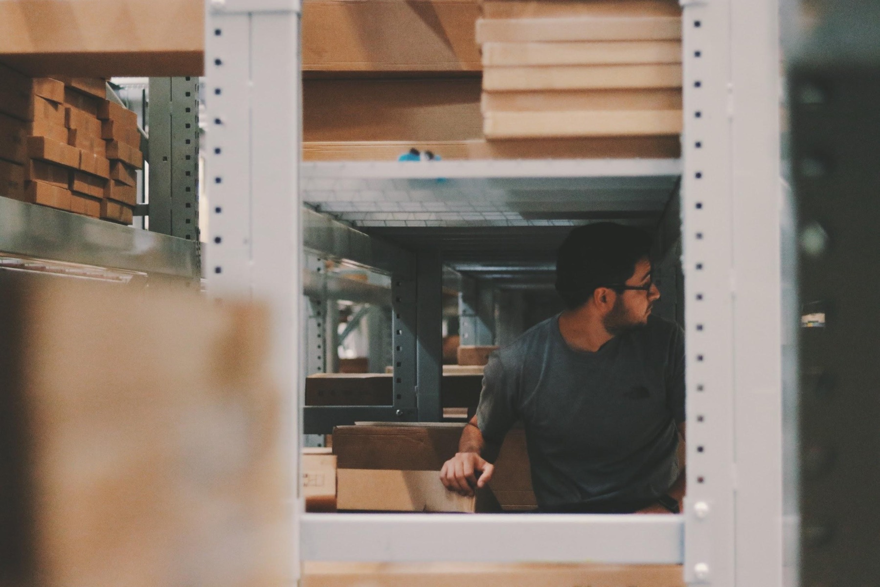 Man organizing packing boxes in the rack Man organizing packing boxes in the rack